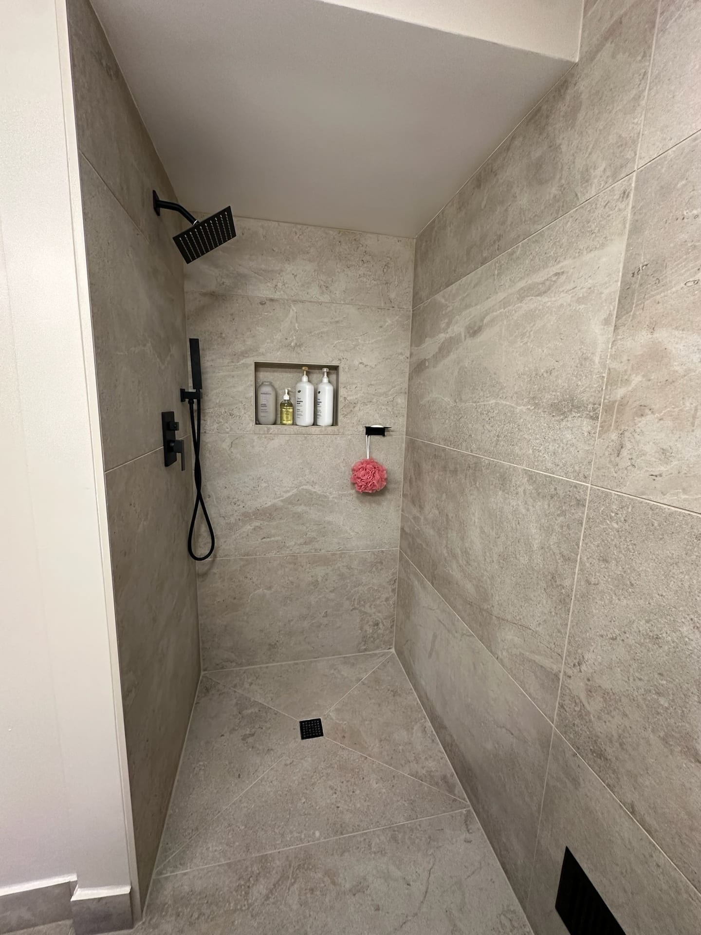 Walk-in shower with large-format gray porcelain tile floor and walls