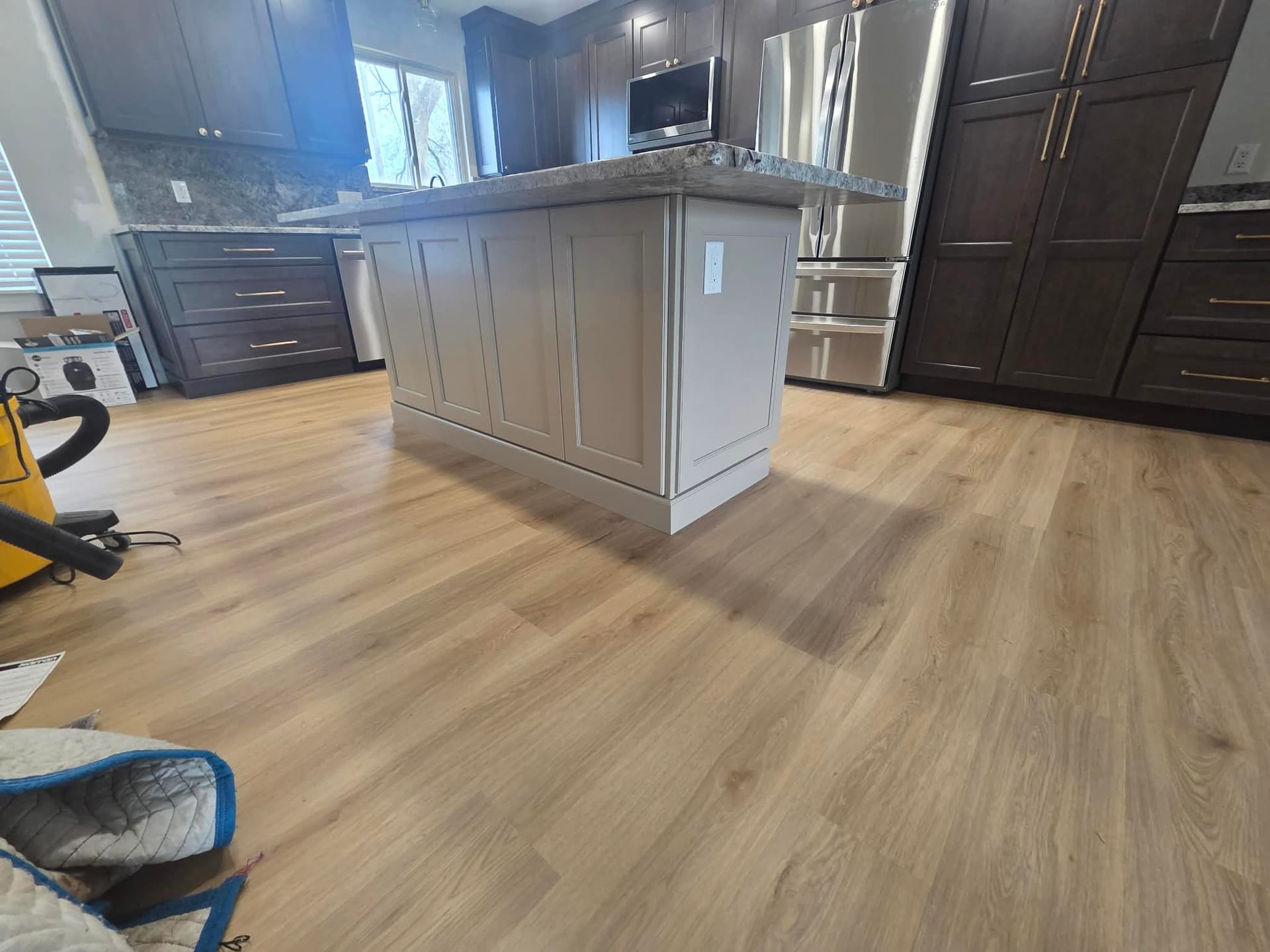 Dark stained shaker-style cabinets with brass-look hardware in a custom kitchen