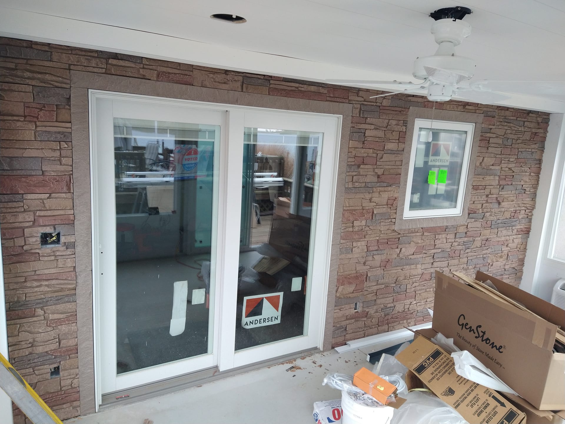 Andersen sliding patio doors set in a stone-veneer exterior wall